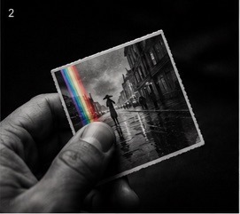 Hand holding a rainy memory photograph with a color edge